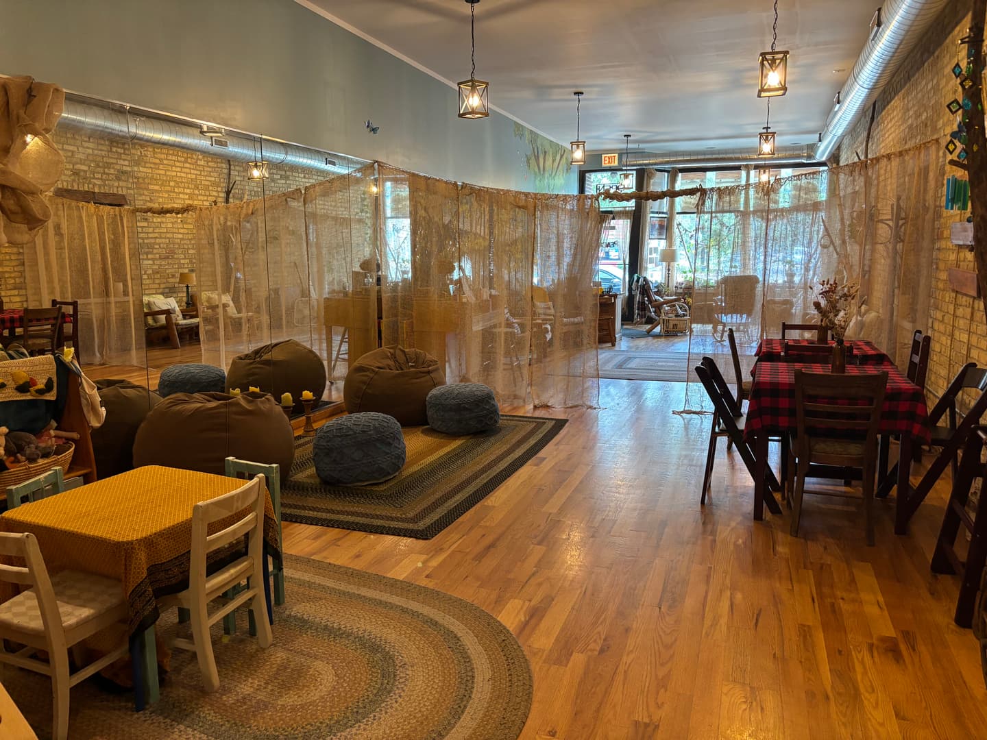 Inside Anne's Haven — a sunlit community room with burlap drapes, braided rugs, and handmade décor