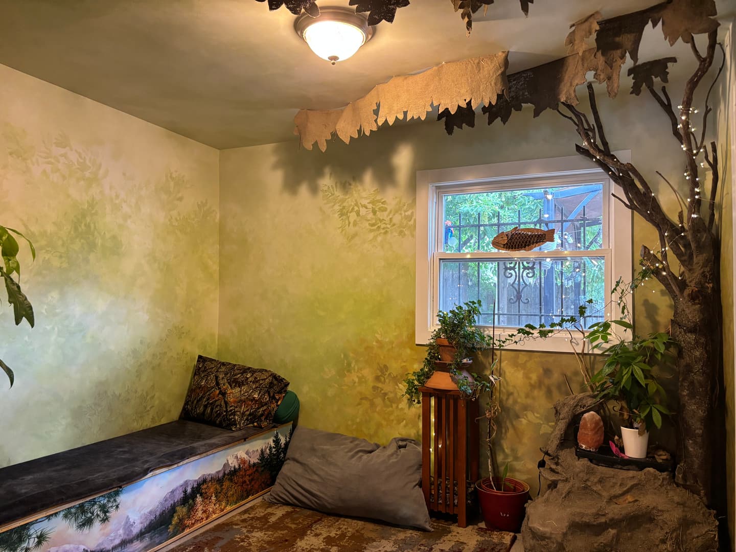 A serene meditation nook with a forest mural, plants, and soft natural light