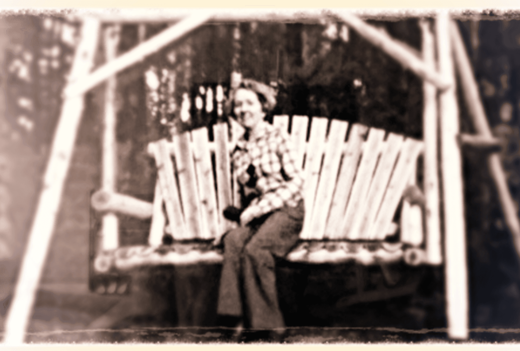 A vintage photograph of Anne, the namesake of Anne's Haven, smiling on a garden swing
